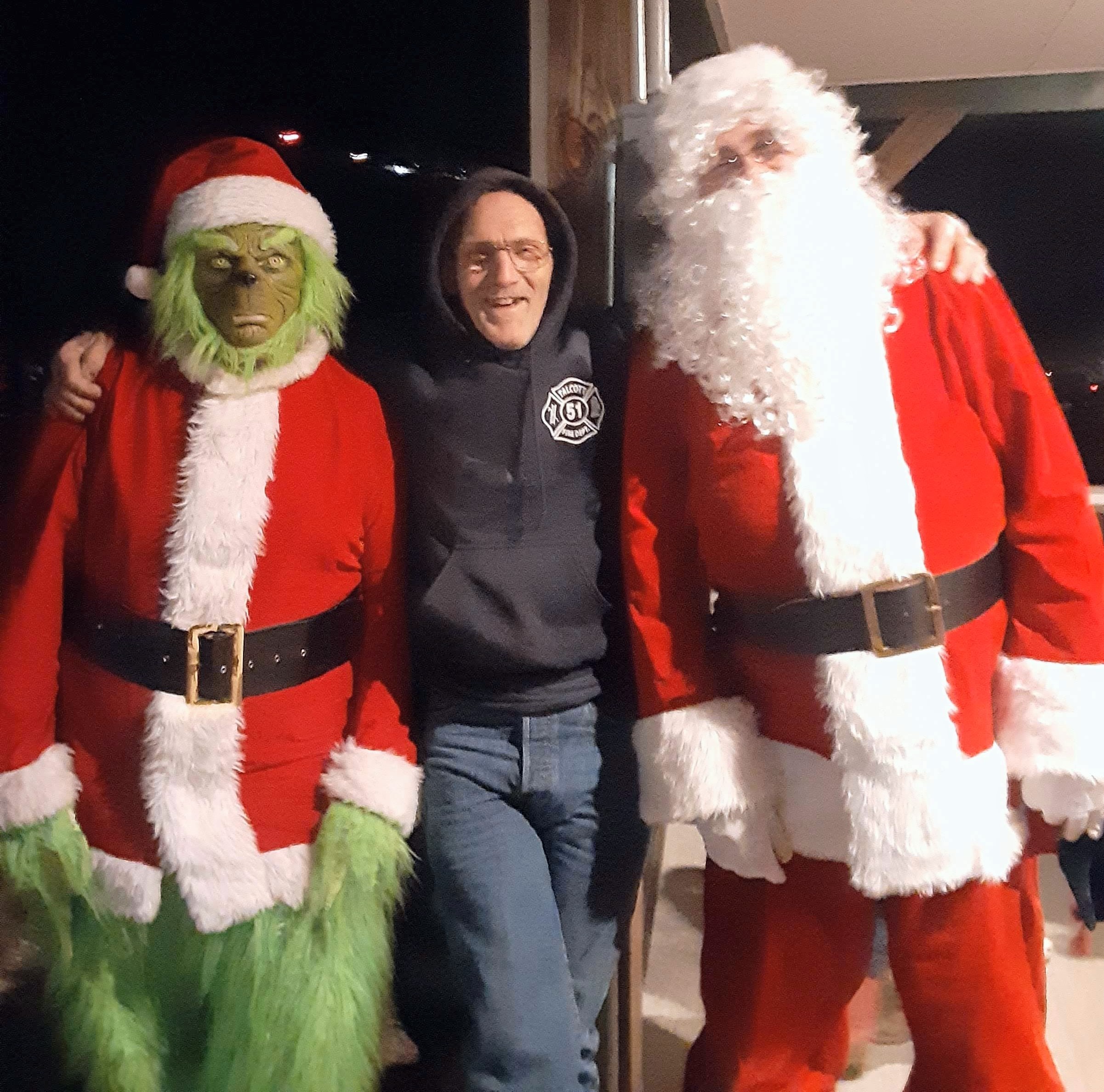 Fire Chief Bill Costco mitis stands between Santa and the Grinch