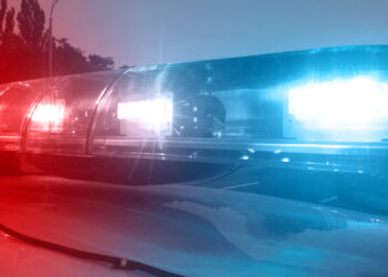Emergency vehicle lights flashing, police car inspecting city, security service