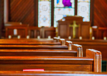 Stained glass windows in small church with wood pews