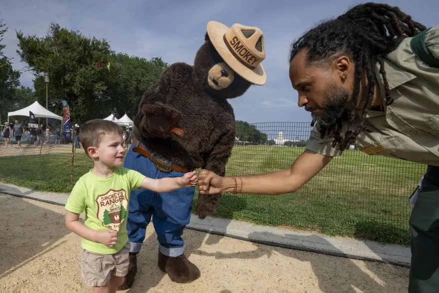 On August 9th, 2025, Smokey Bear turned 81 years young! Here he's celebrating early with a young fan on the National Mall. (USDA Forest Service photo by Preston Keres)