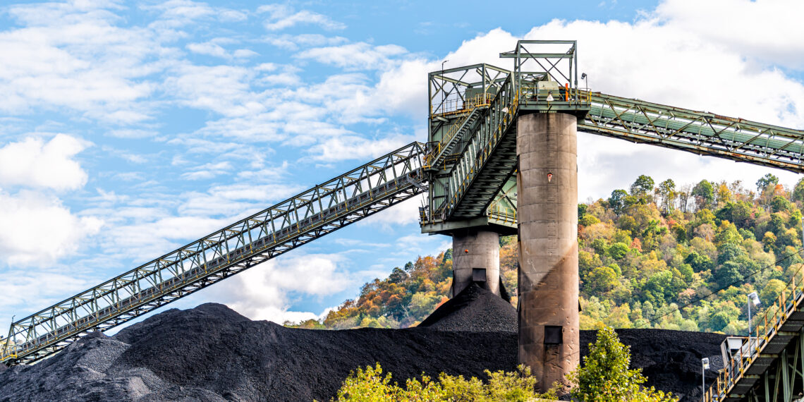 Charleston, West Virginia, USA city with coal mound and industrial factory conveyor belt power plant exterior architecture with elevator lift. Stock image.