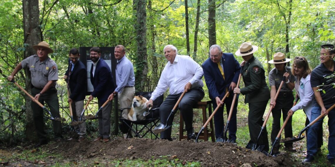 Pictured Left to right: Eric LaPrice, Acting Superintendent, NRGNPP; Tyler Bragg, Interim City Manager,  City of Oak Hill; Tyler Ohrn, Field Representative, Office of Congresswoman Carol Miller; Todd Gunter,  Economic Development Director, Office of Senator Shelley Moore Capito; Baby Dog; U.S. Senator Jim  Justice; WV State Senator Rollan Roberts; Kirsten Talken-Spaulding, Deputy Regional Director, National  Park Service; Eve West. Chief of Interpretation, NRGNPP; Lisa Strader, CEO, Visit SWV; Sammy Lee,  CEO, Guardian Construction.  
