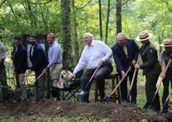 Pictured Left to right: Eric LaPrice, Acting Superintendent, NRGNPP; Tyler Bragg, Interim City Manager,  City of Oak Hill; Tyler Ohrn, Field Representative, Office of Congresswoman Carol Miller; Todd Gunter,  Economic Development Director, Office of Senator Shelley Moore Capito; Baby Dog; U.S. Senator Jim  Justice; WV State Senator Rollan Roberts; Kirsten Talken-Spaulding, Deputy Regional Director, National  Park Service; Eve West. Chief of Interpretation, NRGNPP; Lisa Strader, CEO, Visit SWV; Sammy Lee,  CEO, Guardian Construction.  